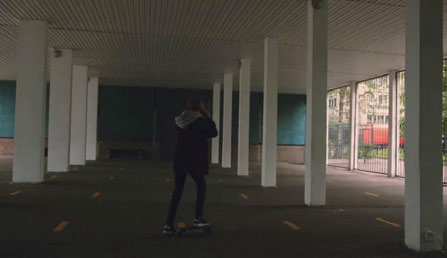 Input video frame: person on a skateboard beneath a covered structure